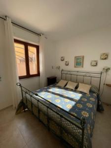 een slaapkamer met een bed met een blauw dekbed bij Civico 8bis Casa Vacanze in Alghero