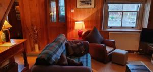 salon z 2 krzesłami i kanapą w obiekcie The Loan w mieście Achiltibuie