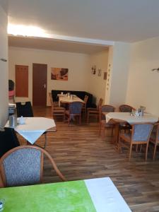 uma sala de jantar vazia com mesas e cadeiras em Hotel zur Altstadt em Calbe
