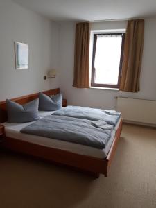 um quarto com uma cama grande e uma janela em Hotel zur Altstadt em Calbe
