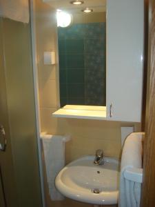 a small bathroom with a sink and a mirror at Linda Bed and Breakfast in Niš