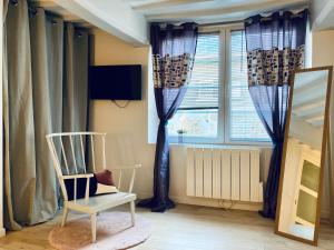 Habitación con silla y ventana en Le Rendez-vous du Pêcheur 4 à 6 pers, en Dieppe