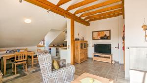 a living room with a dining table and a television at Ferienwohnung Forggensee in Roßhaupten