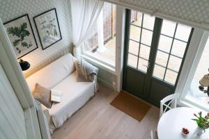 a living room with a white couch and two windows at Anfasteröd Gårdsvik - badstugor med loft in Ljungskile