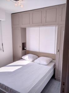 - un lit blanc avec deux oreillers dans une chambre dans l'établissement Résidence de la mer, à Juan-les-Pins
