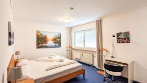 フュッセンにあるFerienbungalow Krahnkeのベッドルーム1室(ベッド1台、デスク、窓付)