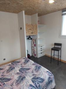 sypialnia z łóżkiem i krzesłem w obiekcie Appartement comme à la maison w mieście Bourbonne-les-Bains