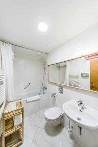 Baño blanco con aseo y lavamanos en Archibald City en Praga
