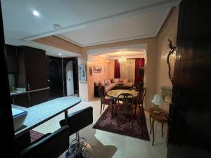 a kitchen and living room with a table and chairs at Luxury apartment in the heart of Gueliz , Wifi, Pool in Marrakech