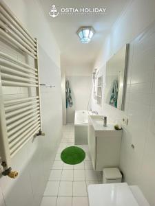 Un baño blanco con lavabo y ducha. en Ostia Holiday Colibrì, en Lido di Ostia 8 fotos más