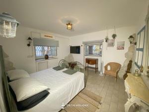 Un dormitorio con una cama blanca y un comedor. en Ostia Holiday Colibrì, en Lido di Ostia