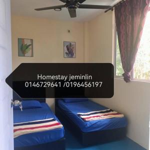 a room with two beds and a window at Jeminlin homestay, budget price in Kota Kinabalu