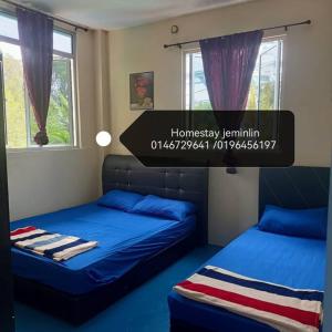 亞庇的住宿－Jeminlin homestay, budget price，一间卧室设有两张带蓝色床单和窗户的床。
