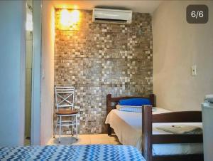 um quarto com 2 camas e uma parede de tijolos em DOM POUSADA em São Gonçalo do Amarante