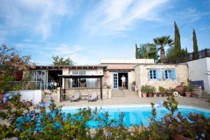 a house with a swimming pool in front of it at The Carob Tree Villa - 3 BR Rustic Luxury Home in Larnaca
