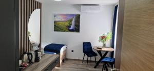 a room with a bed and a table and chairs at M apartmani in Lukavica