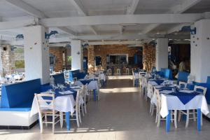 a dining room with blue tables and white chairs at Villaggio La Roccia camping in Lampedusa