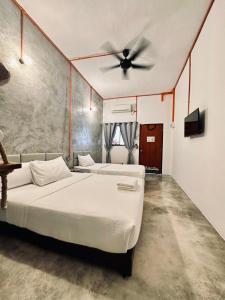 una camera con 2 letti e un ventilatore a soffitto di Ardour Lodge "A" Wing a Tanjung Bungah