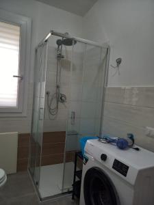 y baño con ducha y lavadora. en Casa Beranu, en Maracalagonis