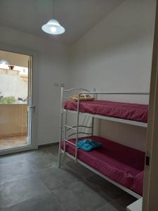 a room with two bunk beds and a window at Casa Beranu in Maracalagonis