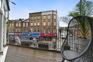 uma cerca com três estátuas de gatos numa varanda em Hampstead Opulence Apartment - Luxurious Split Level Property em Londres