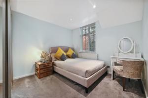 - une chambre avec un lit, un bureau et un miroir dans l'établissement Hampstead Opulence Apartment - Luxurious Split Level Property, à Londres