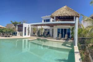 a villa with a swimming pool and a house at Gorgeous Beach House with incredible oceanview in Cuatunalco