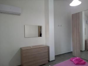 1 dormitorio con tocador y espejo en la pared en Casa Beranu, en Maracalagonis