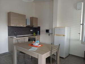 a kitchen with a table with chairs and a refrigerator at Casa Beranu in Maracalagonis