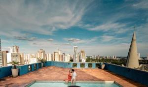 a couple standing on the roof of a building at Elo Hotels Express in Maringá