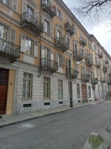 - un bâtiment avec balcon sur le côté d'une rue dans l'établissement La Mole apartment, à Turin