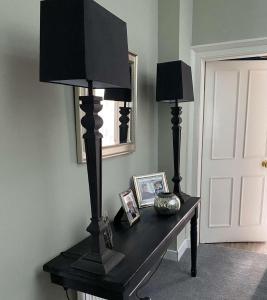 einem schwarzen Tisch mit zwei Lampen darüber in der Unterkunft West End Townhouse in Edinburgh
