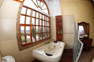 a bathroom with a tub and a sink and a window at Hosteria Loma Larga Cayambe in Cayambe +84 photos