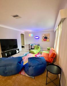ein Wohnzimmer mit einem Sofa und Stühlen sowie einem Flachbild-TV in der Unterkunft Perfect Fun House to Visit Theme Parks in Lake Alfred