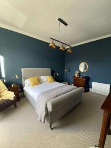 1 dormitorio con 1 cama grande y paredes azules en West End Townhouse en Edimburgo