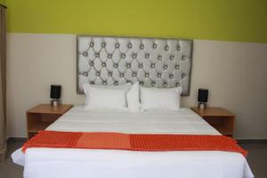 a bedroom with a large bed with a large headboard at Apple Guesthouse in Lothlekane
