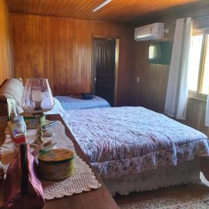 a bedroom with a bed and a table with a table sidx sidx sidx at Casa de campo Cantinho dos Serranos in São Joaquim