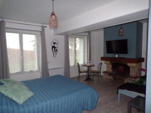 um quarto com uma cama, uma televisão e uma mesa em A la Belle Etoile em Méry-sur-Cher