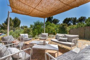 a group of chairs and tables under an umbrella at Villa Moderniste d'architecte vue mer in Toulon