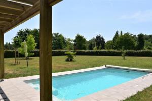 a swimming pool in the middle of a yard at Calm house, swimming pool and garden in Bénesse-Maremne