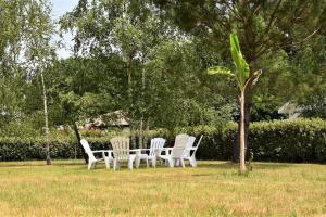 a group of white chairs sitting in the grass at Calm house, swimming pool and garden in Bénesse-Maremne