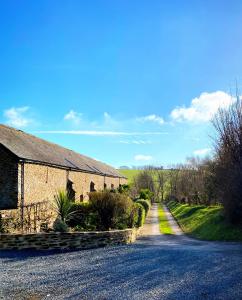 a road next to a brick building with a house at Luxury barn conversion near Salcombe & Kingsbridge, South Devon in Kingsbridge