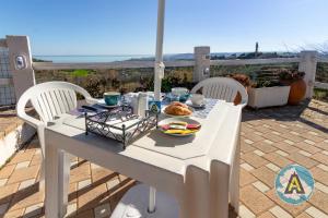 un tavolo bianco con un piatto di cibo sopra di Villino Fonte del Mare a Silvi Paese