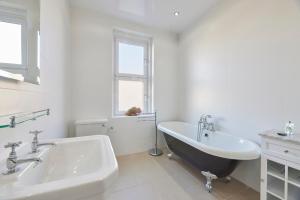 a bathroom with a black and white tub and a sink at Host & Stay - The Cottage in Corbridge in Corbridge