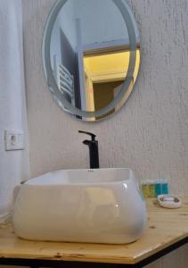 ein weißes Waschbecken mit einem Spiegel auf der Theke in der Unterkunft Greenfield Bakuriani in Bakuriani