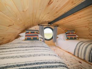 twee bedden in een tiny house met een raam bij Erme in Plymouth