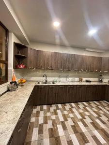 a large kitchen with wooden cabinets and a sink at Guest House on Meskheti in Borjomi