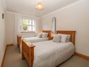 a bedroom with two beds and a window at Bwthyn Clai in Llangefni