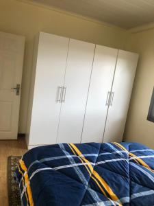 a bedroom with white cabinets and a blue bed at LouieVille One Bedroom Apartment in Lusaka