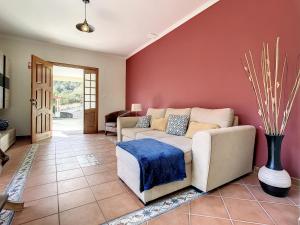 sala de estar con sofá y pared roja en Mountain View Villa by Atlantic Holiday, en São Vicente